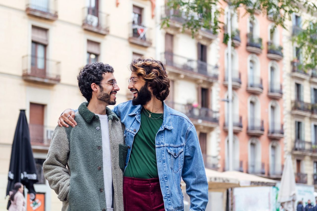 Deux hommes discutent dans un café parisien, un téléphone posé sur la table.